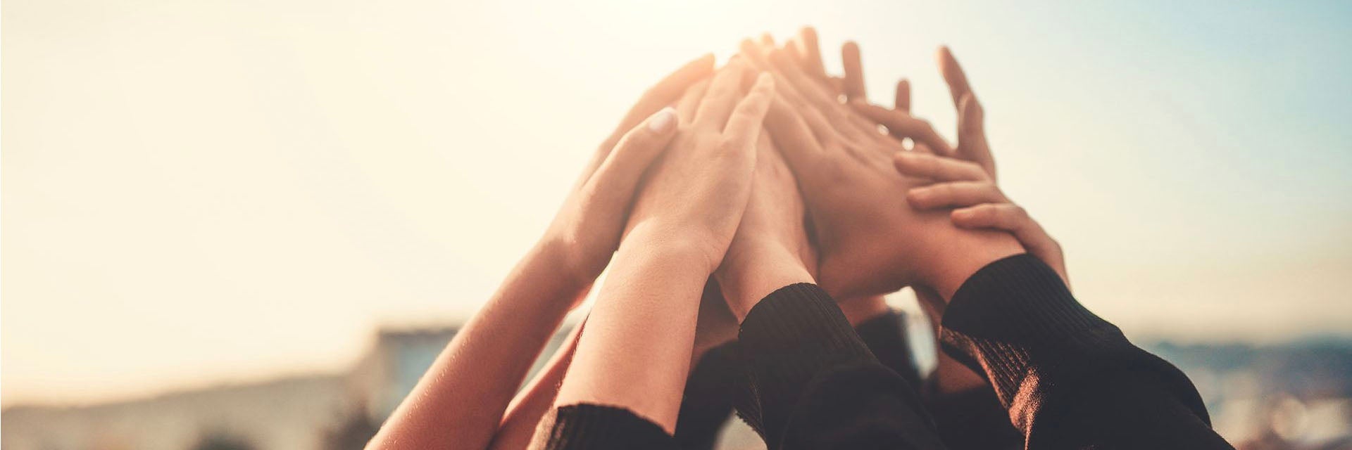 A group of hands raised and touching