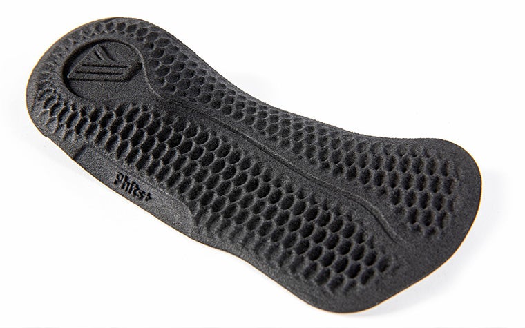 A black 3D-printed phits+ orthotic against a white background.