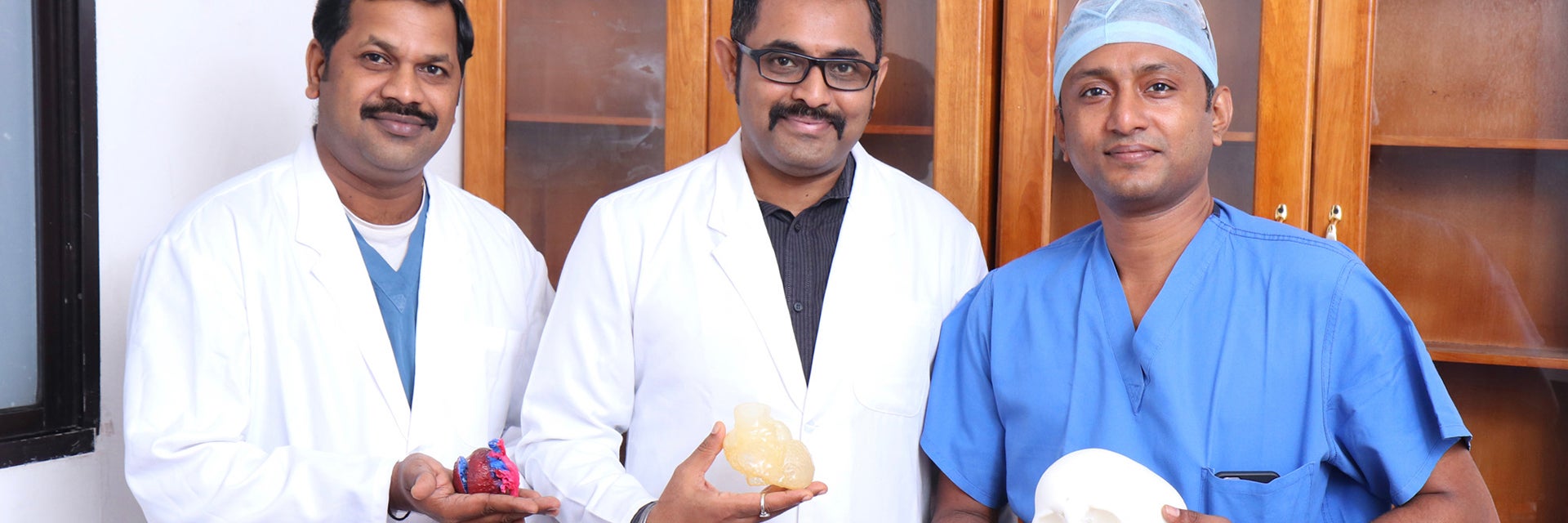 AIMS team holding 3D-printed anatomical models 