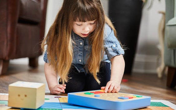 Little girls playing with a puzzle on the floor
