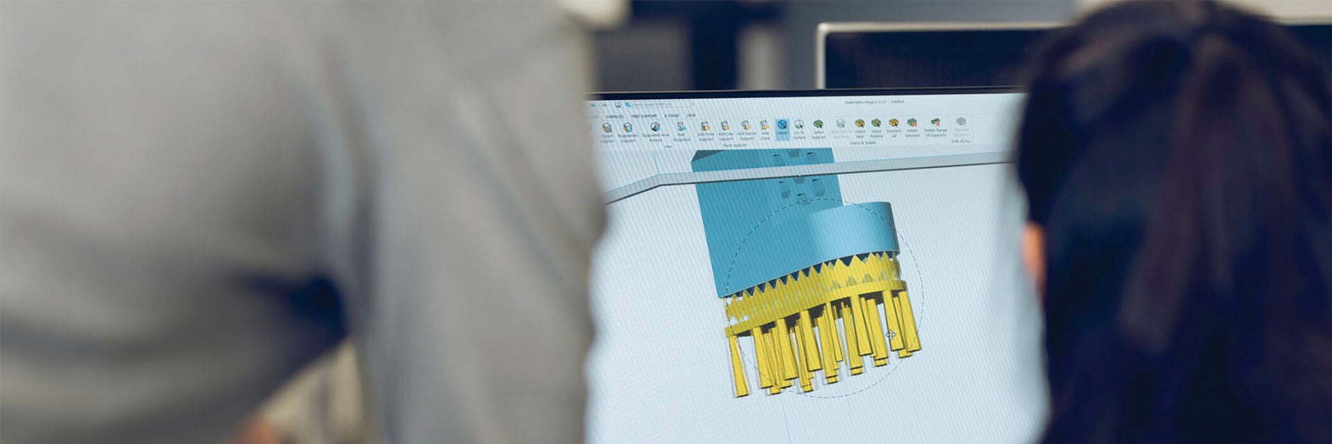 Two people looking at a design in the Magics software