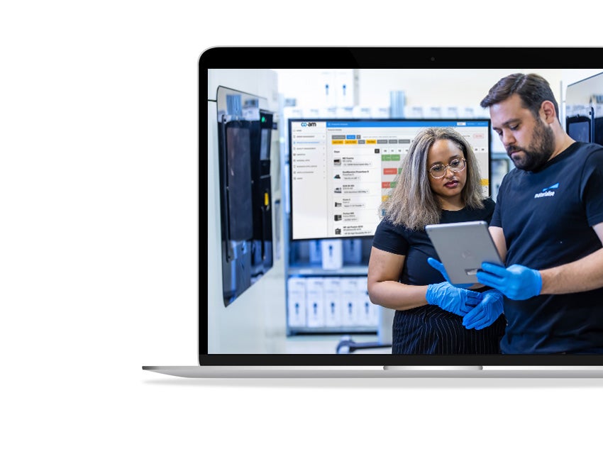 Two Materialise employees discuss a project on a small tablet.