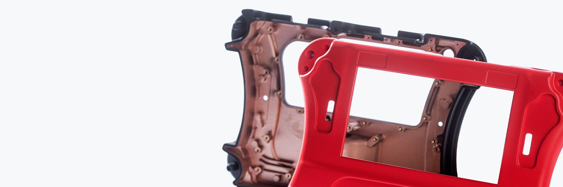 The front of a red vacuum-cast housing in front of the backside of the same part