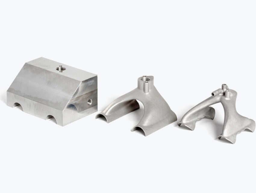 Three variations of the same metal gripper, one designed for conventional manufacturing, one sleeker one designed to be printed, and one even sleeker one with a design optimized for additive manufacturing
