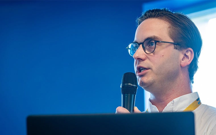 Dr. Renaat Coopman holding a microphone and presenting at the 3D Printing in Hospitals Forum