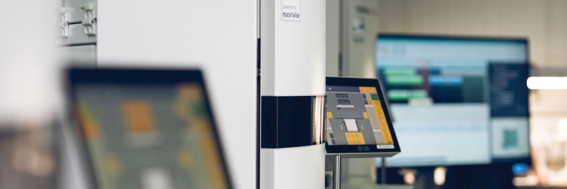 Rows of 3D printers in a production facilitywith their screens on
