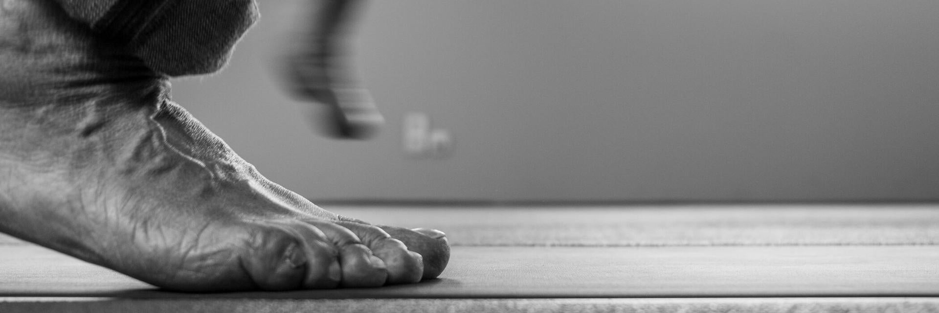 A man walks barefoot over a footscan pressure plate.