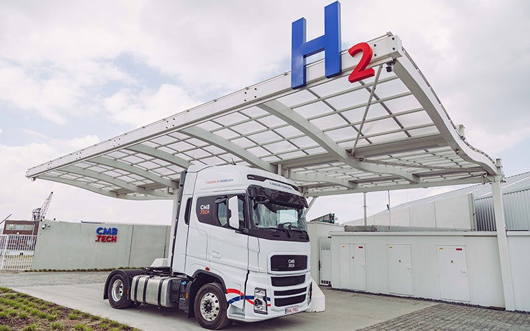 Un camion a idrogeno parcheggiato accanto a una stazione di rifornimento di idrogeno.