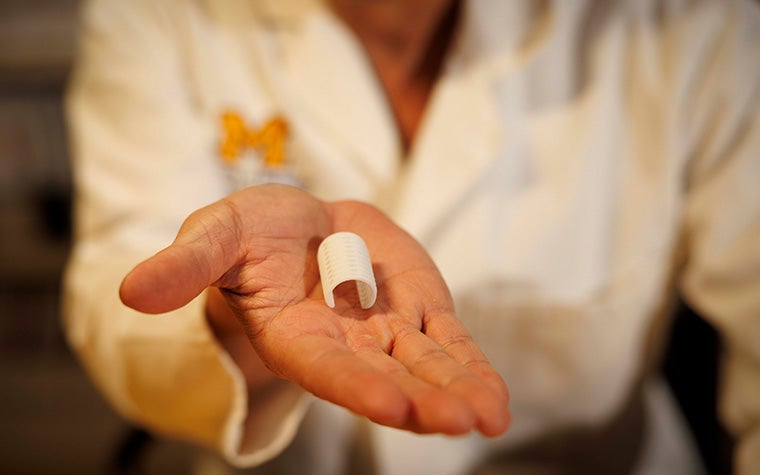 Dr. Richard G. Ohye, MD holding his hand out with the 3D-printed tracheal splint device in his palm