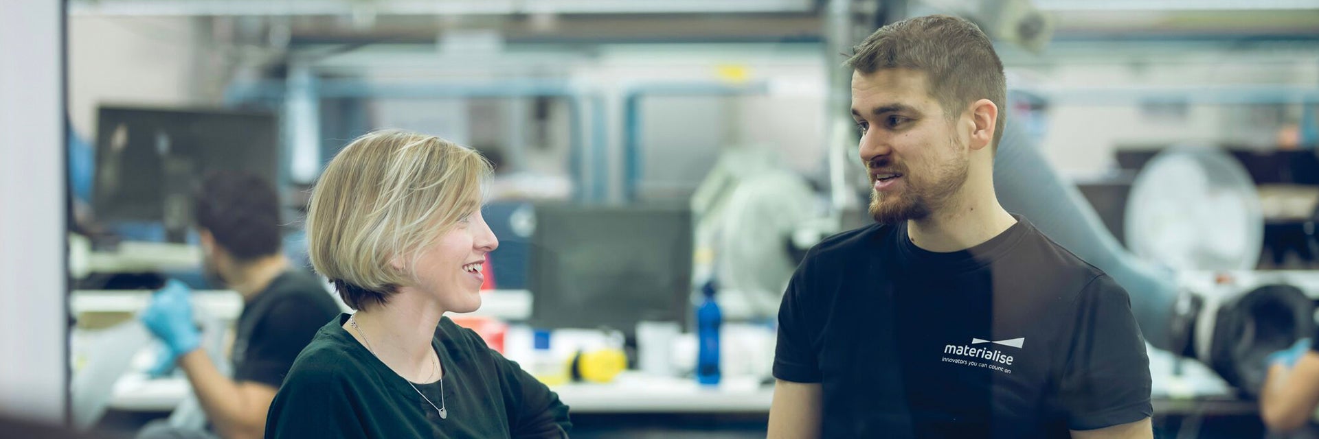 Materialise employees talking in a 3D printing factory