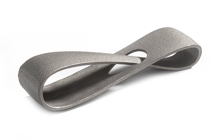 A metal 3D-printed infinity loop made from titanium using selective laser melting. The loop has a smooth, matt finish, achieved through post-machining.