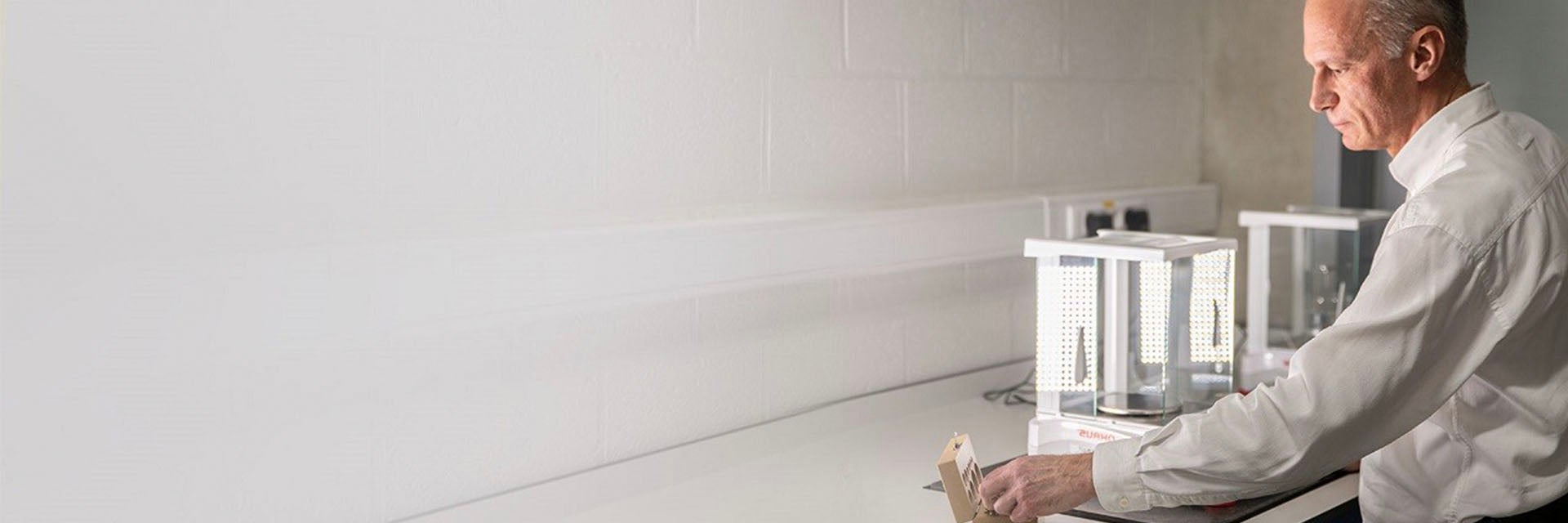 Quality Engineer Eddy Couvreur reaching for a tool in a lab