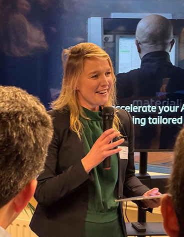 Vice Mayor Maaike Zwart of the City of Delft speaking into a microphone at the opening of Materialise's Aerospace Competence Center