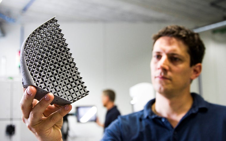 An engineer inspects a 3D-printed metal object