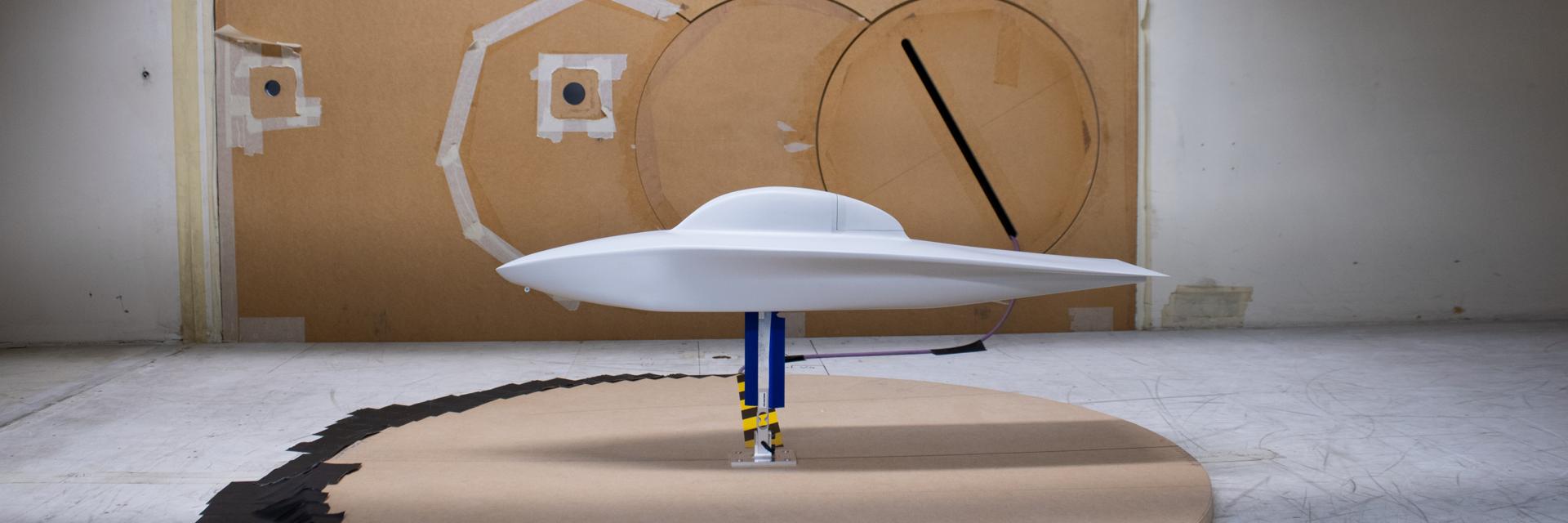 A side-on view of the white 3D-printed replica of the Agoria Solar Car in a wind tunnel. 