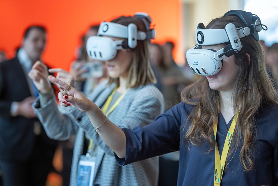 Two 3D Planning and Printing in Hospitals Forum attendees wearing VR headsets and interacting with virtual content using hand gestures.