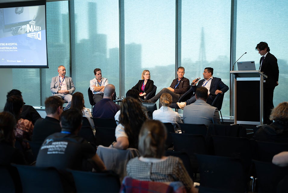 A group of speakers sitting at the front of a room during a panel discussion at the 3D Printing in Hospitals Forum 2024