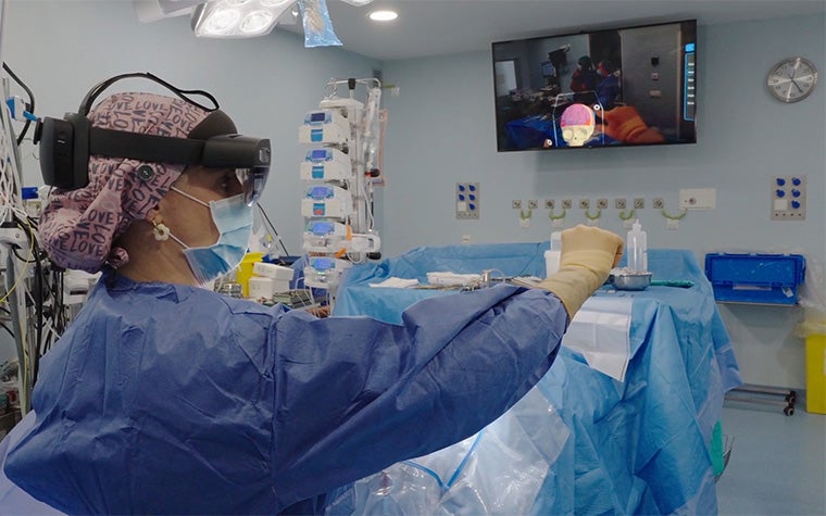 A surgeon wearing augmented reality goggles, reviewing a 3D anatomical model in the operating room