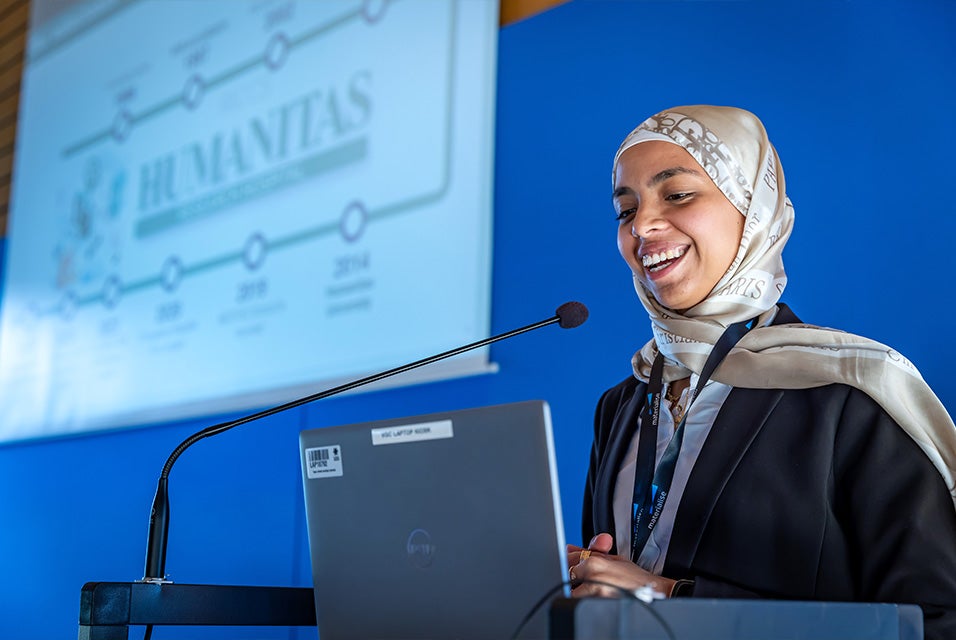 Speaker Nada Mansour smiling while looking at a laptop and presenting at the 3D Planning and Printing in Hospitals Forum 2026