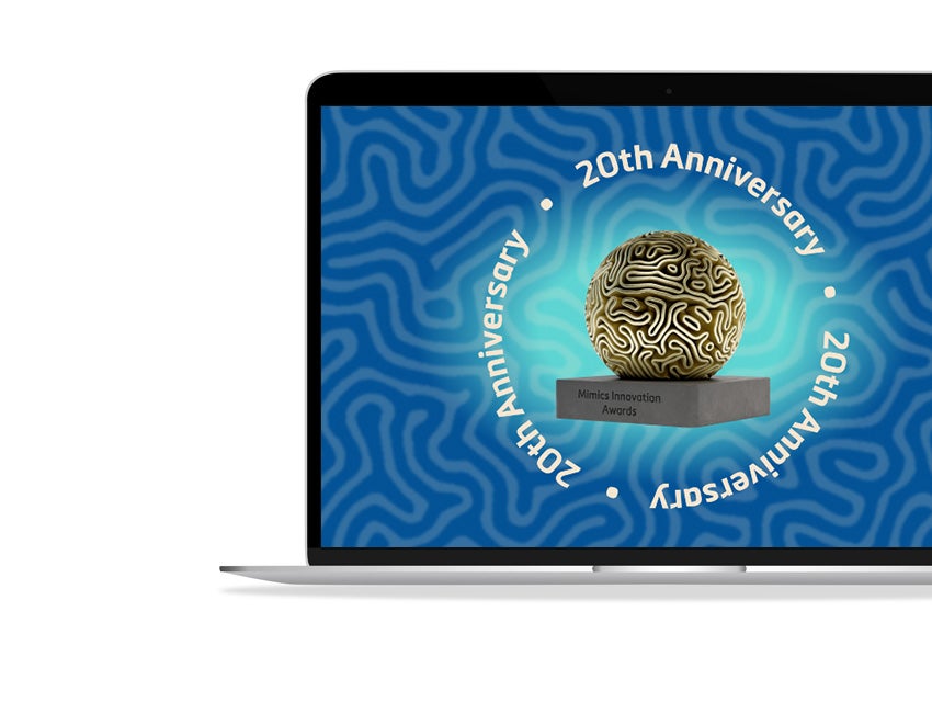 A laptop is on a white background. A blue screensaver is displayed on the laptop with the words "20th anniversary," and this sentence is repeated three times around a trophy with a golden globe. The words "Mimics Innovation Awards" are on the trophy's base.