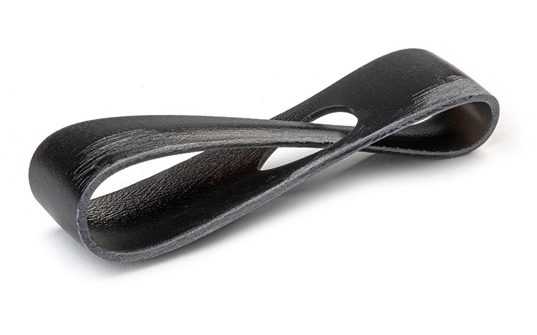 Un bucle negro impreso en 3D realizado con Taurus mediante estereolitografía, terminado con la eliminación de todas las marcas de soporte.