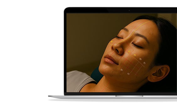 Laptop displaying an image of a woman with lines and numbers superimposed on her face.