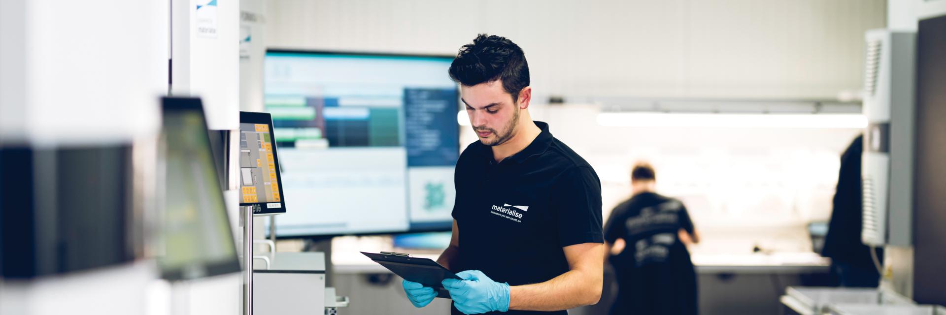 Man reviewing papers in a 3D printing production