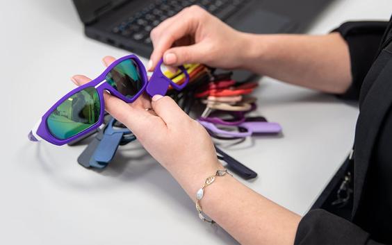 Person looking through eyewear color samples while holding 3D-printed sunglasses