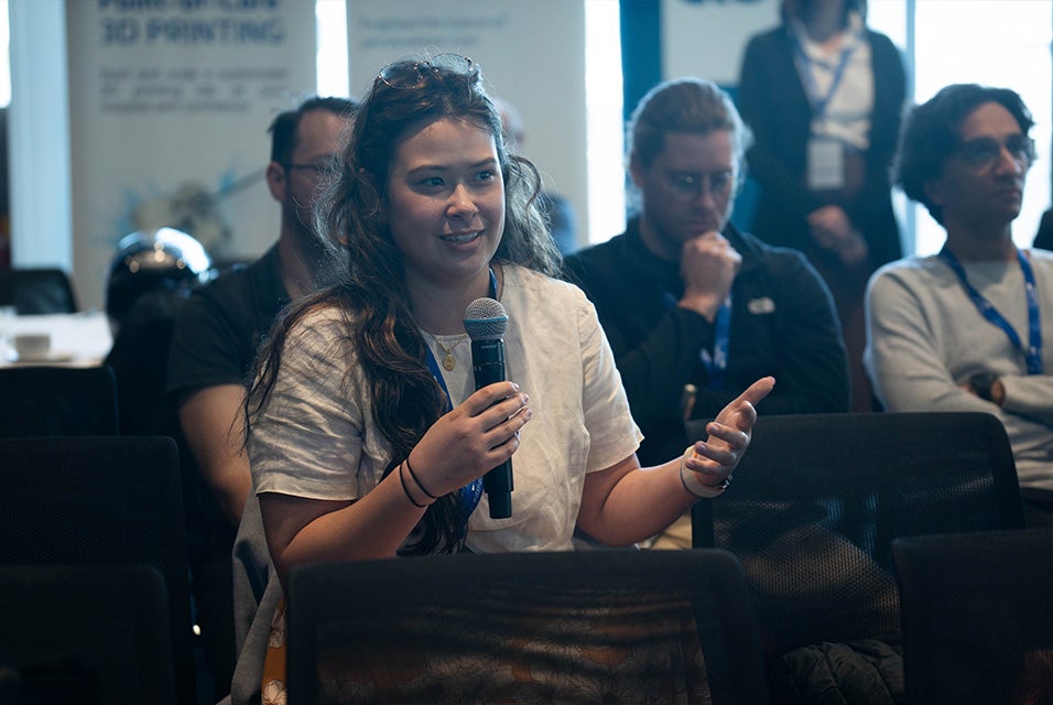 A 3D Printing in Hospitals Forum 2024 attendee holding a microphone, asking a question