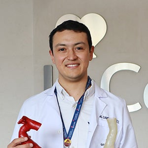 Camilo Eduardo Perez Cualtan holding 3D-printed anatomical models