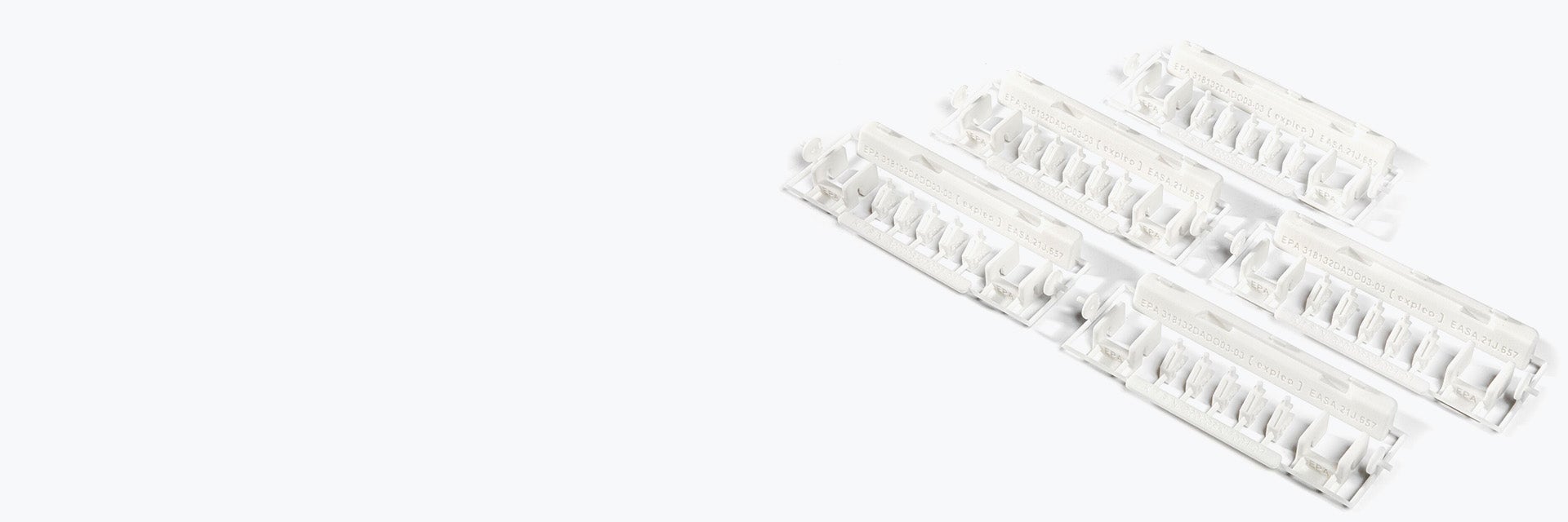 Eine Sammlung weißer 3D-gedruckter Expleo-Reparatursets, hergestellt aus PA 2241-FR mit SLS.