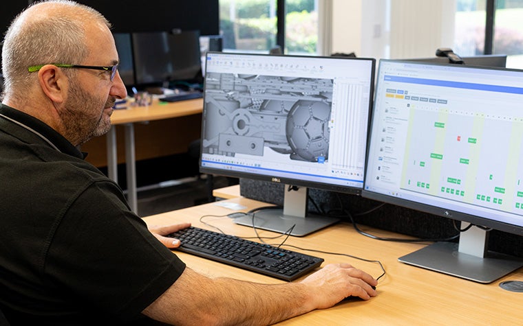 A Ricoh 3D team member looking at additive manufacturing build data on his computer via the CO-AM software ecosystem.