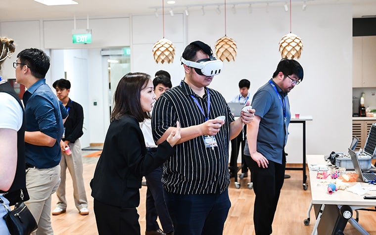 Attendees at the APAC 3D Printing in Hospitals event testing out a vr headset.