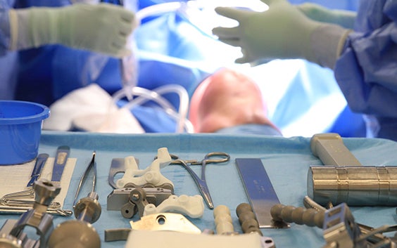 Surgical instruments laid out ready for use in knee surgery on the patient who is lying on the bed in the OR 
