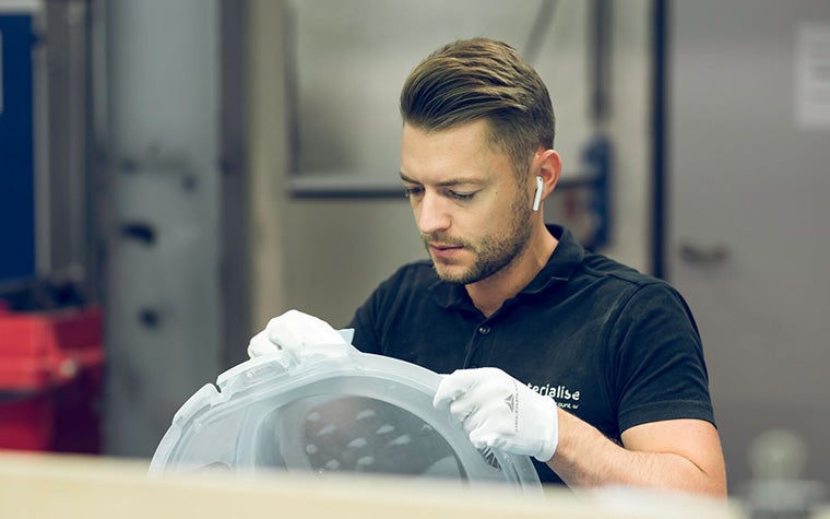 Man sanding a 3D-printed part in a Materialise production facility
