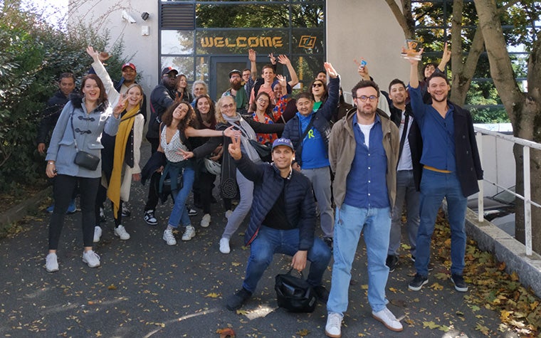 Materialise Paris team smiling and waving in front of the office building