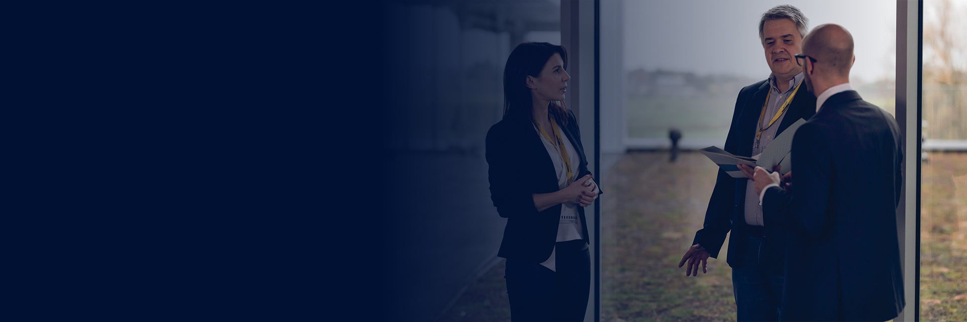 비즈니스 복장으로 대화하는 여성 한 명과 남성 두 명