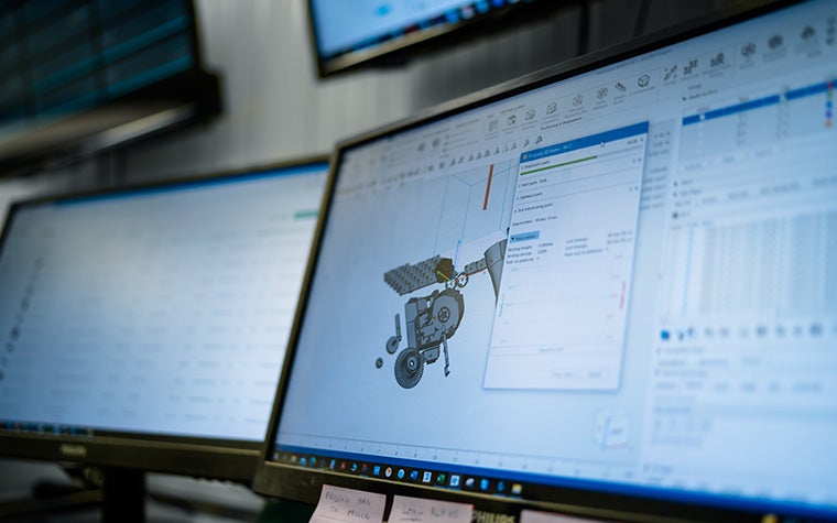 Nesterモジュールを搭載した2台のモニターのクローズアップ。画面にはネスティング段階の3Dモデルが表示され、もう1つにはリストが表示されている。