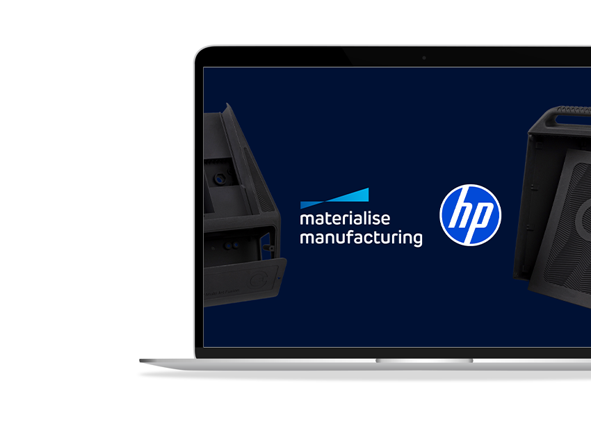 A laptop screen showing the HP and Materialise Manufacturing logos next to each other with a couple of 3D prints on either side