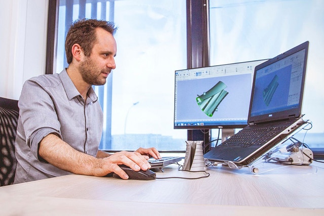 A man using a desktop computer with the magics essentials software