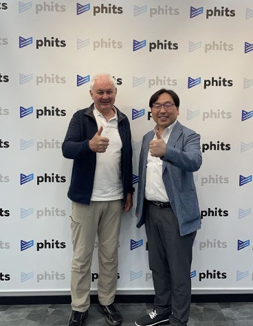 Fried Vancraen and Dr. Kyounghoon Chai stand in front of a wall covered in phits logos.