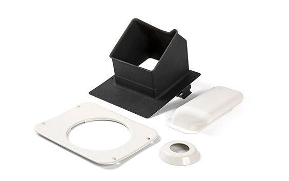 Gezeigt werden vier 3D-gedruckte Ersatzteile aus flammhemmendem Polyamid: eines ist schwarz und drei sind weiß. Alle vier Teile sind häufig in Flugzeugkabinen zu finden. Diese Teile werden für 328 Support Services hergestellt.