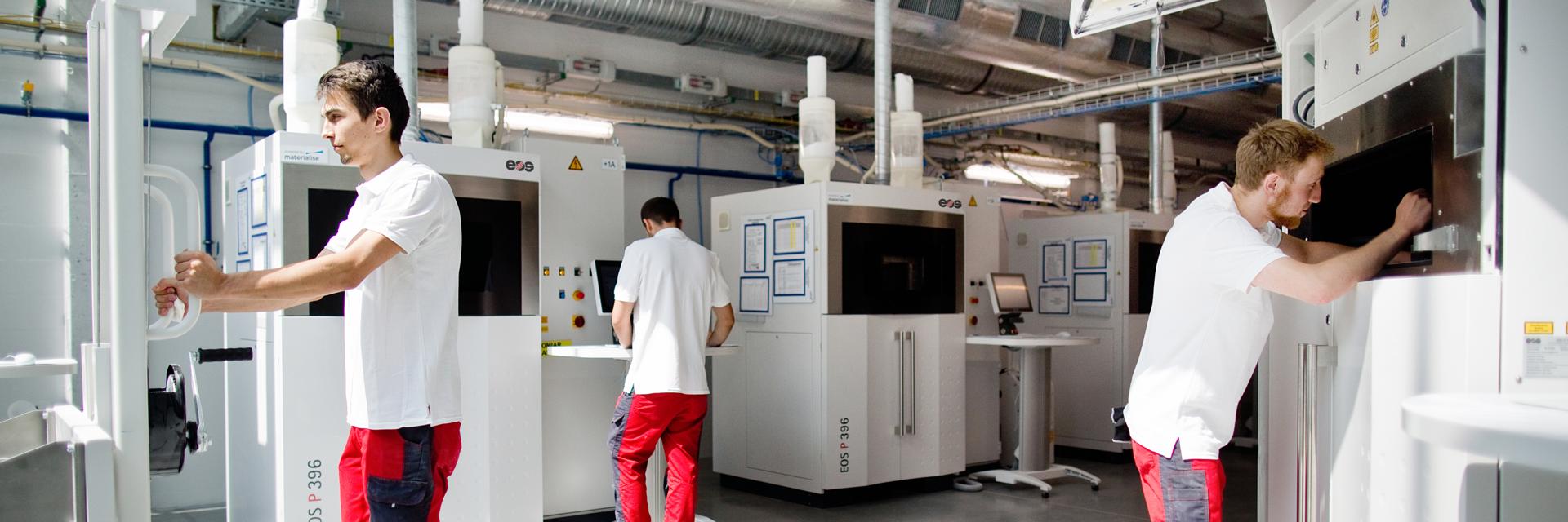 Técnicos de Materialise que trabajan en un área de producción de sinterizado láser