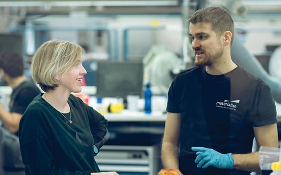 Materialise employees talking in a 3D printing factory