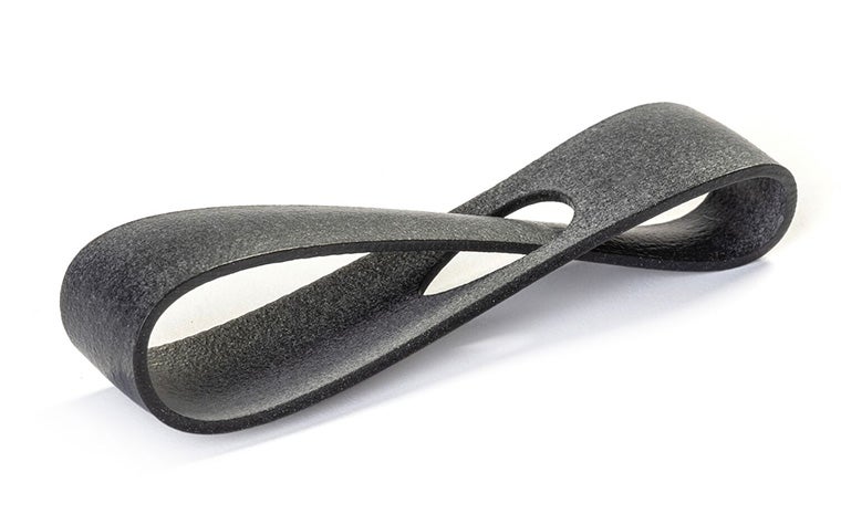 A dark gray 3D-printed loop made from PA 12S using Multi Jet Fusion, with an extra-smooth finish.