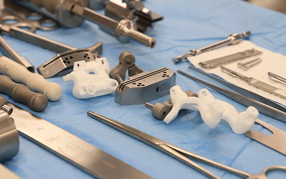 Surgical tools, including 3D-printed surgical guides, on a lined plate before a surgery
