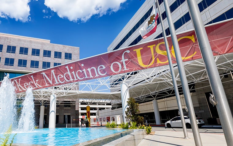 A banner say "Keck Medicine of USC," hanging above a fountain in front of the center's building