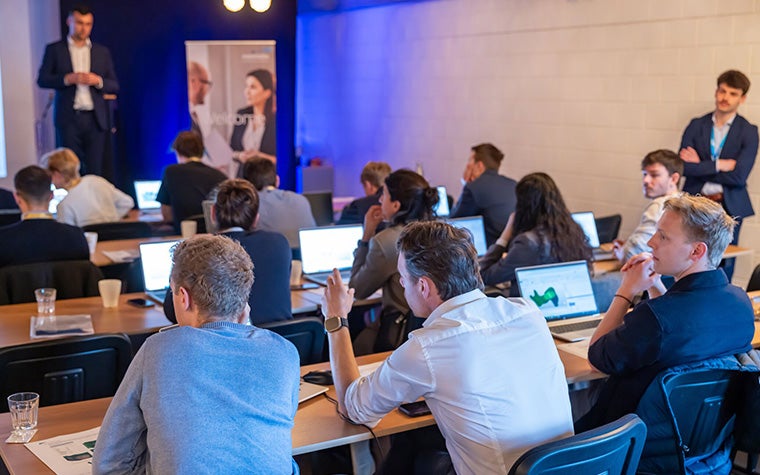 A group of 3D Printing in Hospitals Forum 2024 attendees sitting at tables for a Mimics training