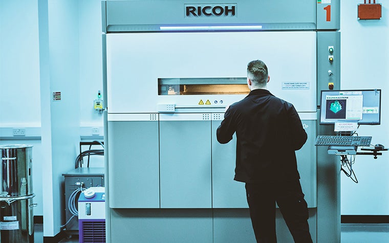 リコー3Dプリンターの前に立つ男性