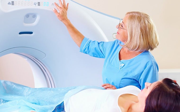 A woman and a patient in a CT scan.